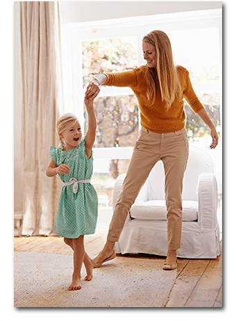 Mother and daughter dancing in the living room